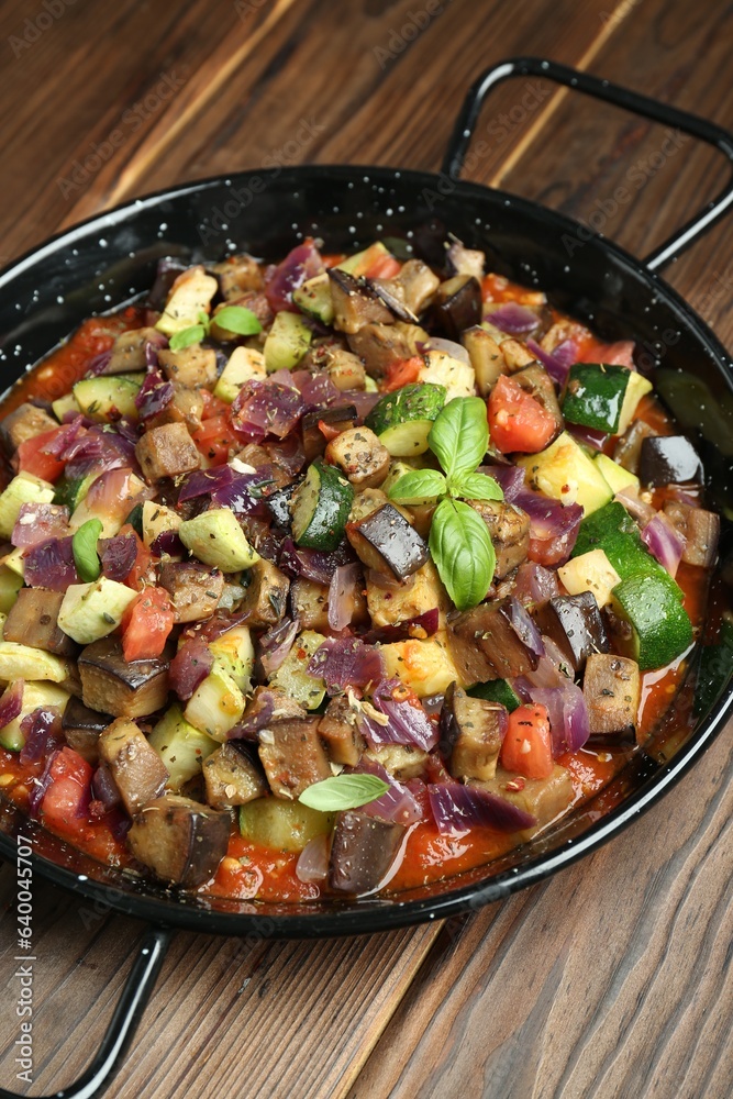 Delicious ratatouille in baking dish on wooden table, closeup Delicious ratatouille in baking dish on wooden table, closeup
