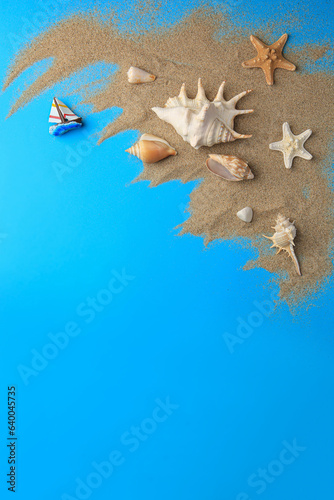 Flat lay composition with beautiful starfishes and sand on blue background. Space for text