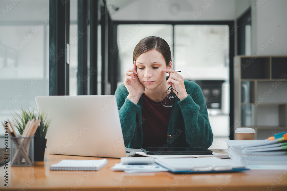 Overworked businesswoman suffering from headache and thinking how to end work. Overworked businesswoman suffering from headache and thinking how to end work.