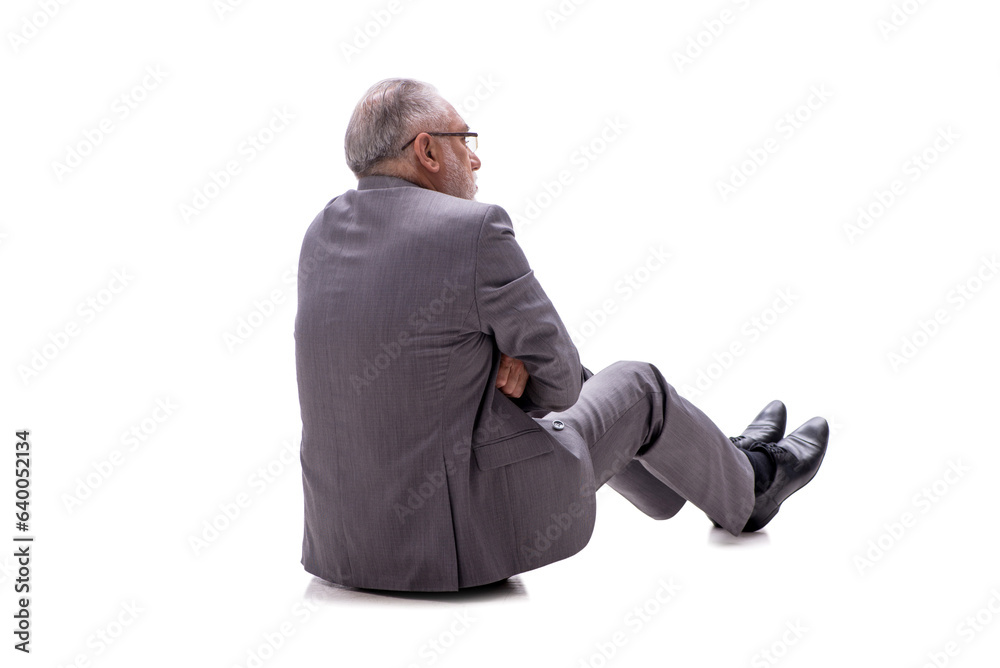 Old businessman sitting on the floor isolated on white Old businessman sitting on the floor isolated on white