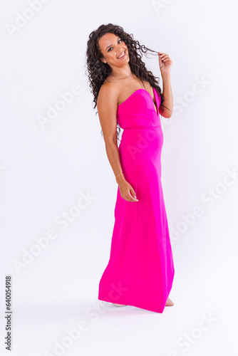 Young diverse woman in bright pink dress against white background