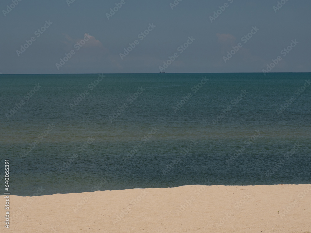 sandy beach landscape and the sea surface is beautiful and clear. the bright green sea far and wide. clear blue sky. 