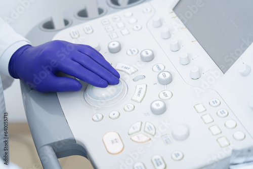 Hand of doctor sonographer pushing buttons on ultrasound control panel. High quality photo