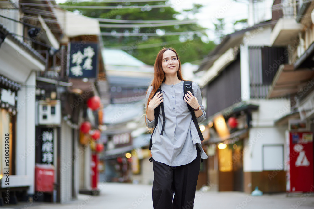 商店街を歩くリュックを背負った外国人の旅行者