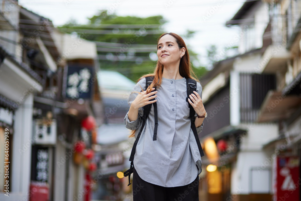 商店街を歩くリュックを背負った外国人の旅行者 商店街を歩くリュックを背負った外国人の旅行者