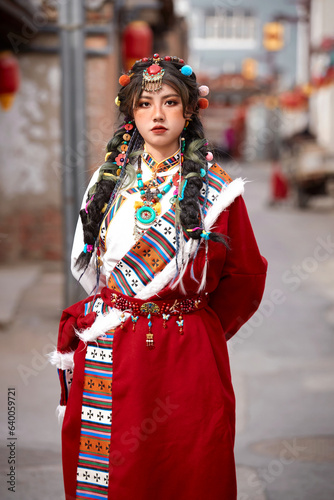 The girl dressed in Tibetan attire is taking photos in the ancient city