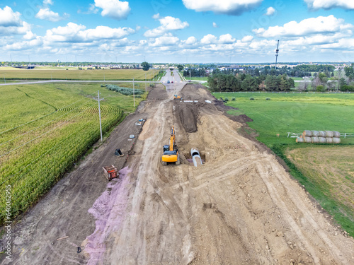 High angle view of a road construction project starting in a corn field and leading into a city.  photo