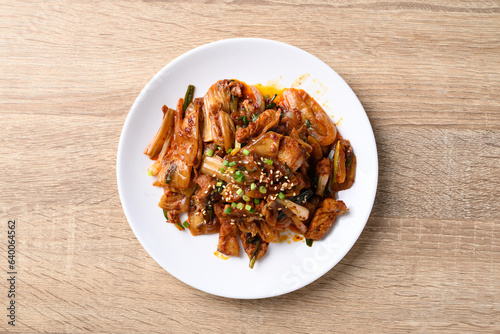 Korean stir fried kimchi cabbage with pork on wooden background, Table top view
