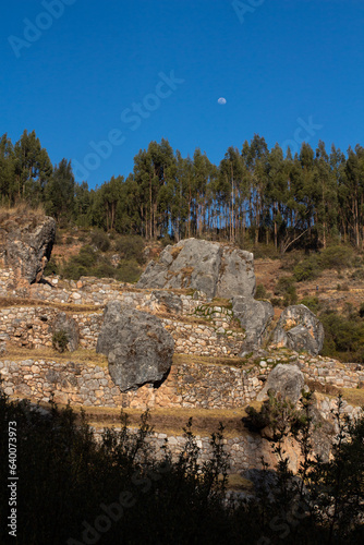 Zona Arqueológica de Inkilltambo en Cusco, Perú, rodeada de rocas grandes, árboles y un cielo despejado photo