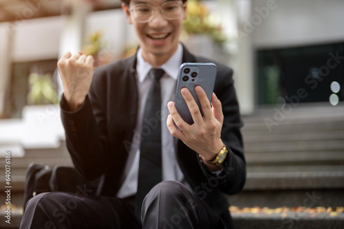 Cropped image, A cheerful Asian businessman receiving good news on the phone, got a new job