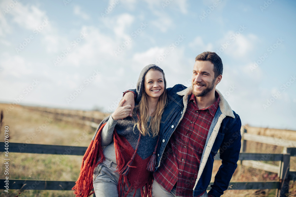Young caucasian couple walking on a field in the countryside