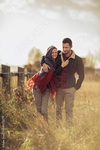 Young caucasian couple walking on a field in the countryside