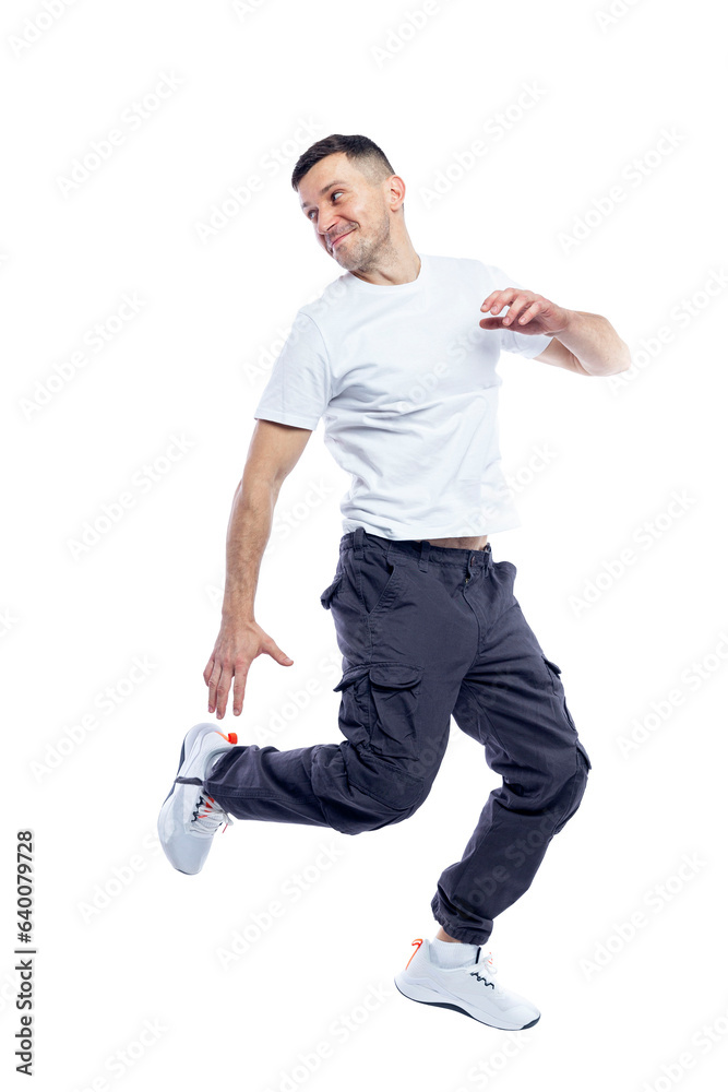 Joyful man jumping. Brunette in a white T-shirt and dark trousers. Sports, activity and positive. Full height. Isolated on white background. Space for text. Joyful man jumping. Brunette in a white T-shirt and dark trousers. Sports, activity and positive. Full height. Isolated on white background. Space for text.