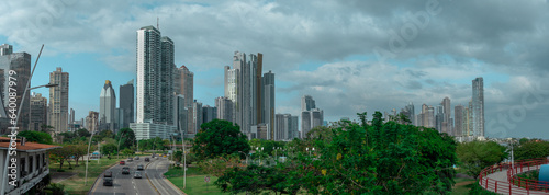 Cityscape of Panama downtown with visible high skyscrapers and business houses, looking from across the highway overpass with cars rushing under.