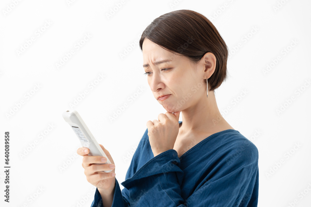 エアコンの温度に悩む女性 エアコンの温度に悩む女性