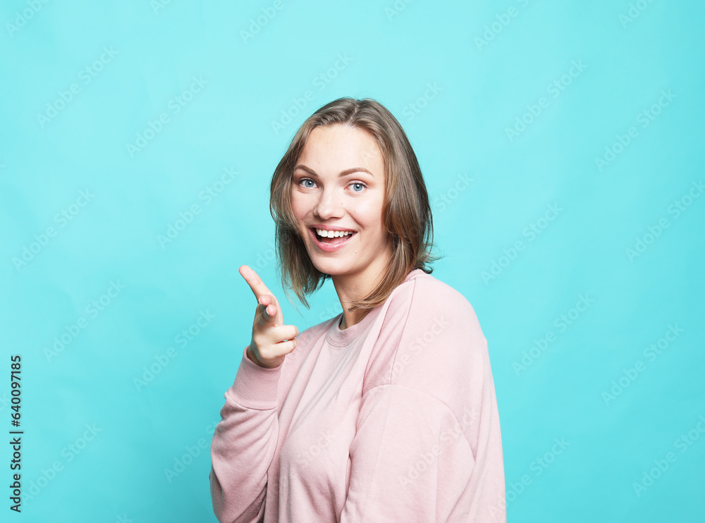 Portrait of cheerful young woman feels joyful and laughing isolated over blue background Portrait of cheerful young woman feels joyful and laughing isolated over blue background