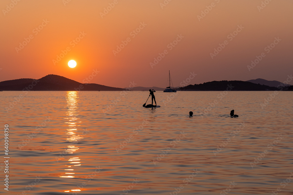 Sunset on the Adriatic Sea in Croatia, with the people swimming