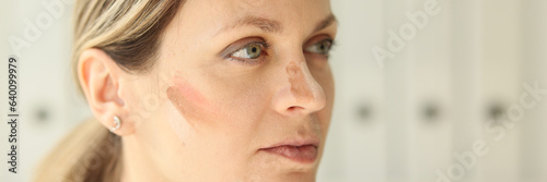 A close-up on the female face of a tonal cream smear