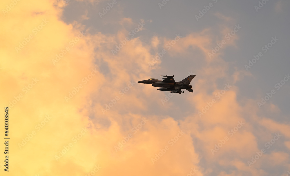Bucharest International Air Show. F16 military fighter airplane flying against sunset sky. Military aviation aircrafts and war missiles industry.