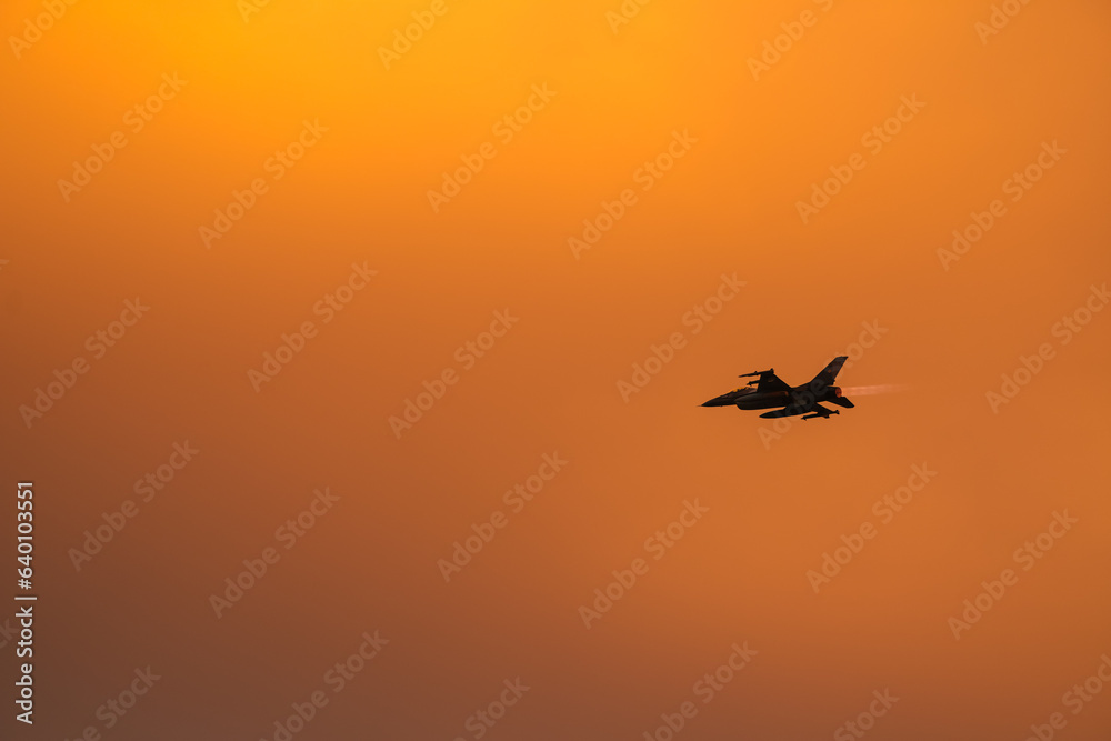 Bucharest International Air Show. F16 military fighter airplane flying against sunset sky. Military aviation aircrafts and war missiles industry.