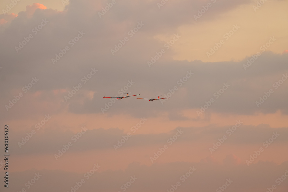 Two air glider flying against sunset sky, part of White Wings team, during Bucharest International Air Show.