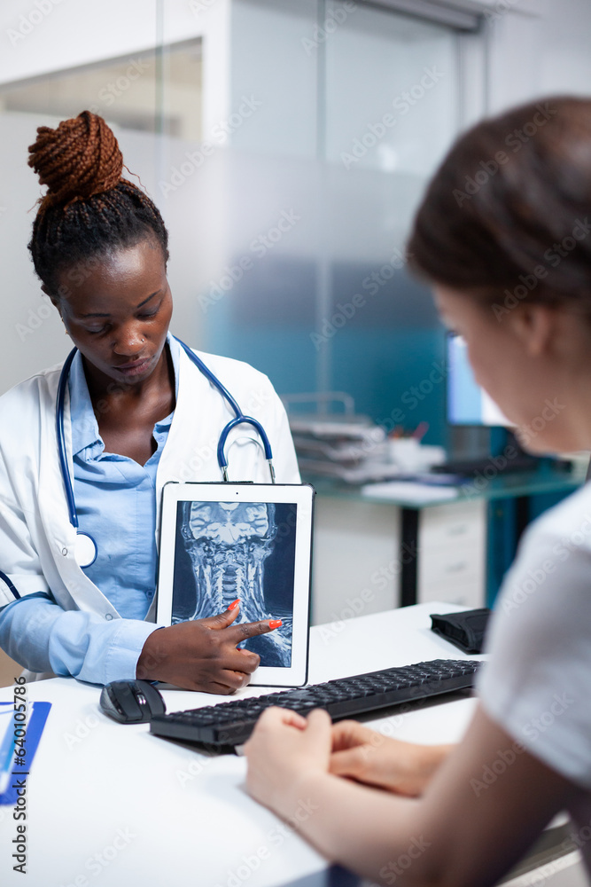Radiology specialist doctor with x-ray ct scan of cervical injury giving medical result to patient during clinical appointment. Radiologist presenting treatment for soreness, pain, ache symptoms Radiology specialist doctor with x-ray ct scan of cervical injury giving medical result to patient during clinical appointment. Radiologist presenting treatment for soreness, pain, ache symptoms