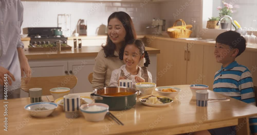 Happy Korean Family of Four Enjoying a Delicious Meal Together in Their Kitchen at Home. They are Sharing a Traditional Meal Made with Love and Care. Children Excited for Food Happy Korean Family of Four Enjoying a Delicious Meal Together in Their Kitchen at Home. They are Sharing a Traditional Meal Made with Love and Care. Children Excited for Food