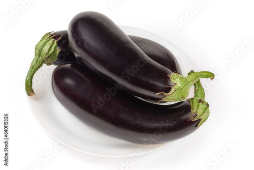 Raw freshly harvested purple eggplants on dish on white background