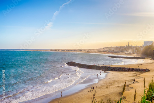 Fototapeta Naklejka Na Ścianę i Meble -  The Canary Islands Ideas. Sunset Scenic  View of Playa del Ingles Beach in Maspalomas With Sand Dunes and Rocks on Shore at Gran Canaria in Spain