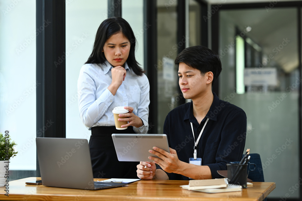 Male and female economists working on investment and marketing projects in office Male and female economists working on investment and marketing projects in office