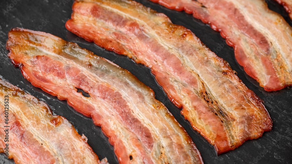 Frying bacon slices in oven. Crispy pieces of fried delicious bacon. Traditional breakfast Frying bacon slices in oven. Crispy pieces of fried delicious bacon. Traditional breakfast