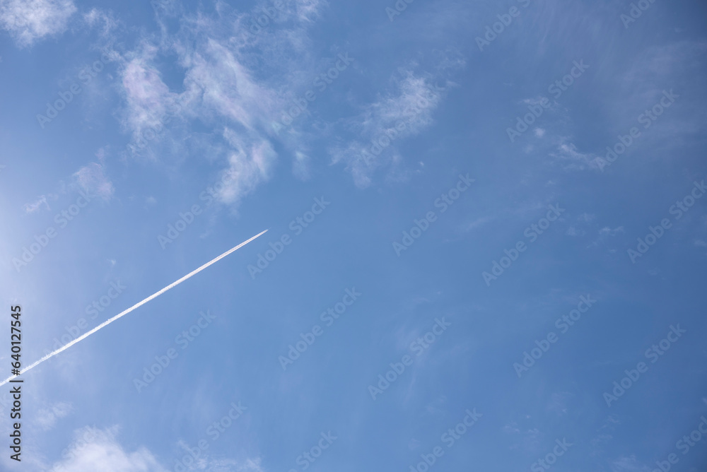 airplane flies in white clouds in a blue sky. airplane flies in white clouds in a blue sky.