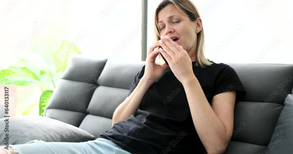 Tired woman talking on phone at home on couch. Fatigue and sleepiness Tired woman talking on phone at home on couch. Fatigue and sleepiness