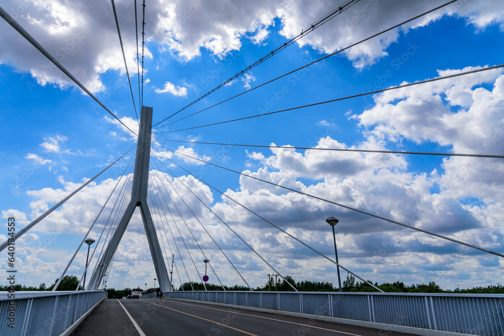 Cable-stayed bridge with blue sky and white clouds in sunny day. Taiyang bridge on Sun Island, Harbin, China. Asia's first single tower forward-leaning cable-stayed bridge without backstays.