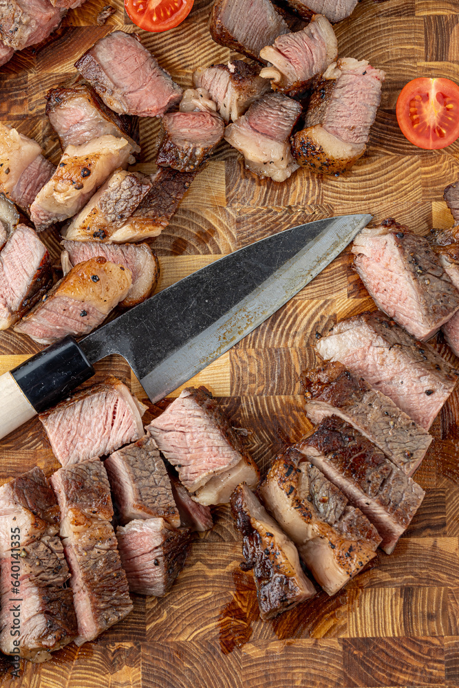 A steak on a cutting board with herbs and spices.Grilled beef te A steak on a cutting board with herbs and spices.Grilled beef te