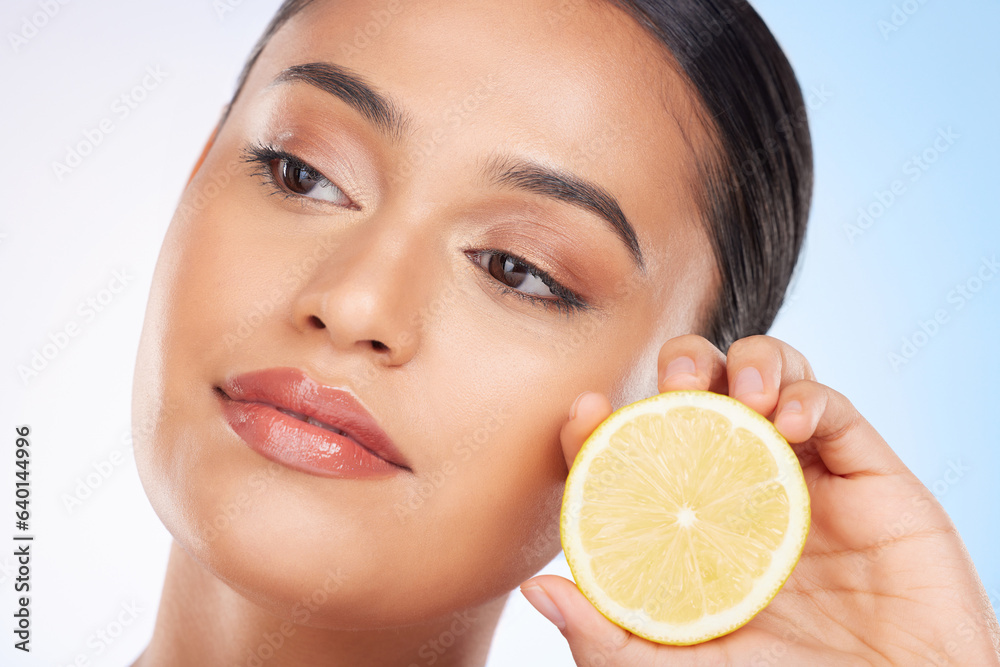 Beauty, lemon and face of studio woman with citrus fruit for organic anti aging treatment, facial detox or aesthetic cosmetics. Vitamin C benefits, spa wellness and self care model on blue background Beauty, lemon and face of studio woman with citrus fruit for organic anti aging treatment, facial detox or aesthetic cosmetics. Vitamin C benefits, spa wellness and self care model on blue background