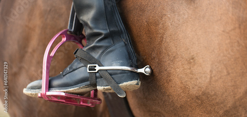Photos Foot of the athlete in a stirrup astride a horse, the foot of the rider, sitting