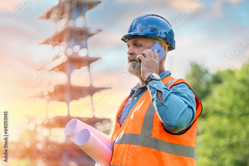 A man site engineer surveyor working with theodolite total station EDM equipment on a building construction site outdoors