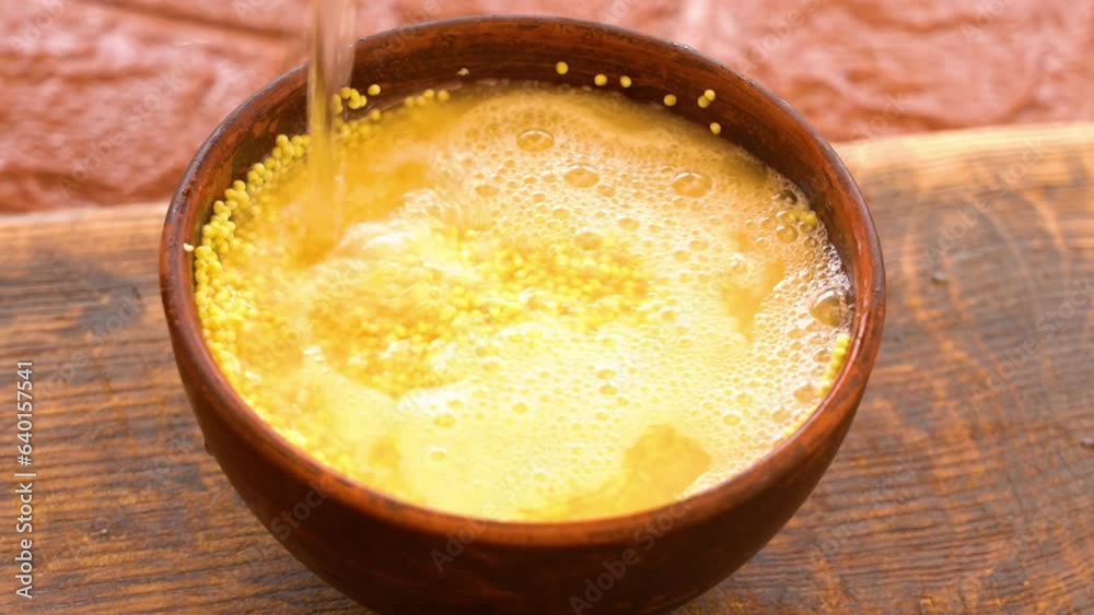 yellow millet in a bowl is poured with water yellow millet in a bowl is poured with water