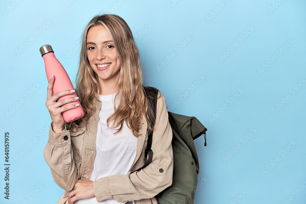 Naklejka premium Traveler with backpack and thermos in blue studio