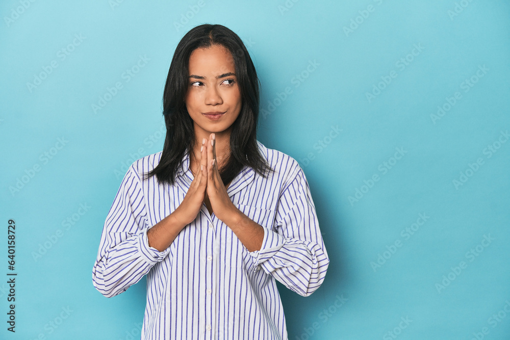 Filipina young woman on blue studio making up plan in mind, setting up an idea. Filipina young woman on blue studio making up plan in mind, setting up an idea.