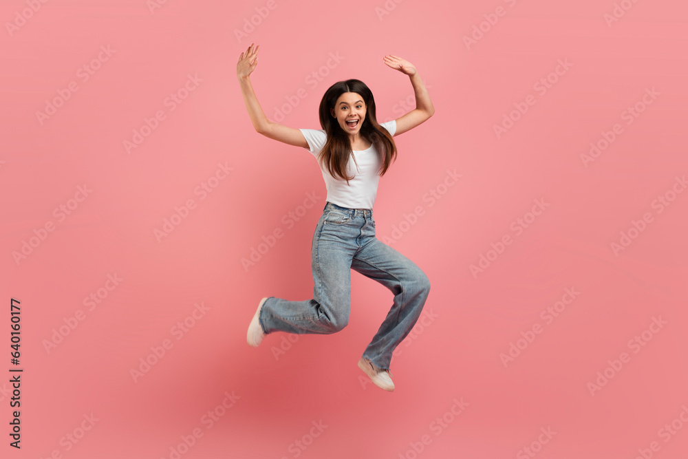 Cheerful Beautiful Teen Girl Jumping In Air Over Pink Studio Background
