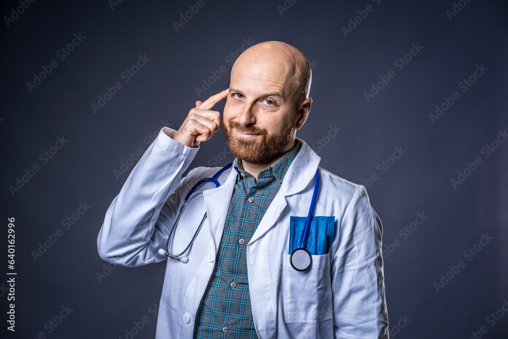 Photo of doctor with beard and stethoscope posing thinking with blue background and medical white coat Photo of doctor with beard and stethoscope posing thinking with blue background and medical white coat