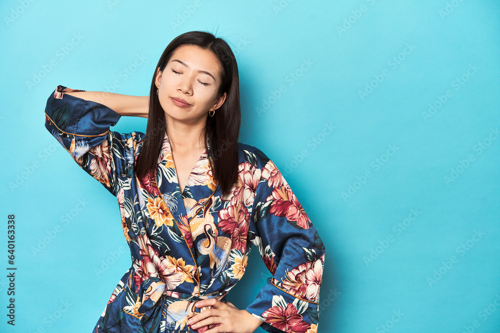 Elegant young Asian woman in kimono, studio shot touching back of head, thinking and making a choice. Elegant young Asian woman in kimono, studio shot touching back of head, thinking and making a choice.