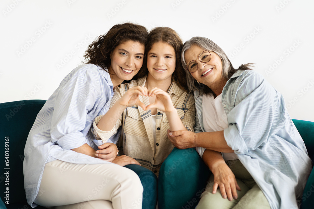 Cheerful caucasian teenager girl, adult mother and old grandmother make heart gesture with hands Cheerful caucasian teenager girl, adult mother and old grandmother make heart gesture with hands
