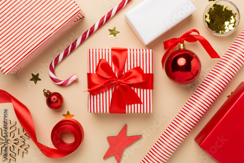 Gift boxes with paper's rools and christmas decoration on color background, top view