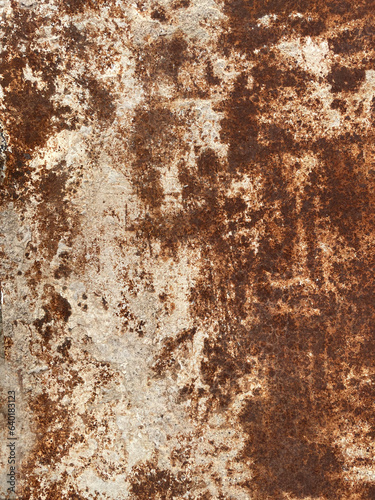 Rusty metal surface as grunge texture for background. Old door  closeup. Corroded metal plate with yellow-brown rust marks  scratches  blue oxidized spots. Worn  aged iron or steel industrial panel.