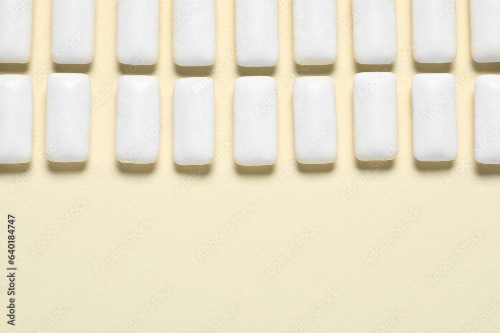 Tasty white chewing gums on beige background, flat lay. Space for text Tasty white chewing gums on beige background, flat lay. Space for text