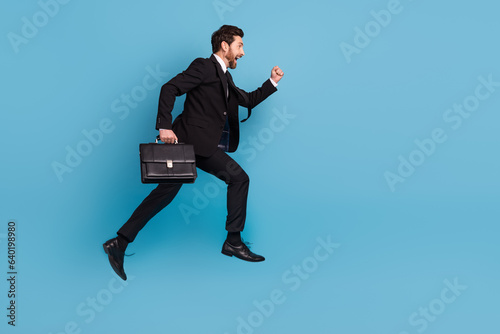 Full length photo of smart excited professional dressed black suit jumping running empty space isolated blue color background