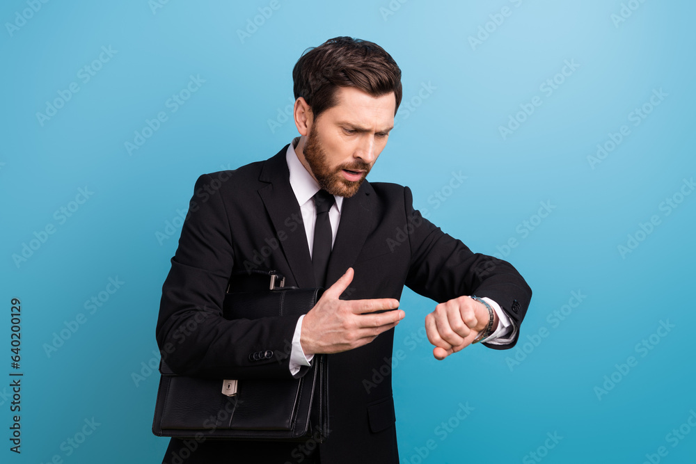 Photo of unhappy shocked secretary wear black tuxedo looking wristwatch late work isolated blue color background Photo of unhappy shocked secretary wear black tuxedo looking wristwatch late work isolated blue color background